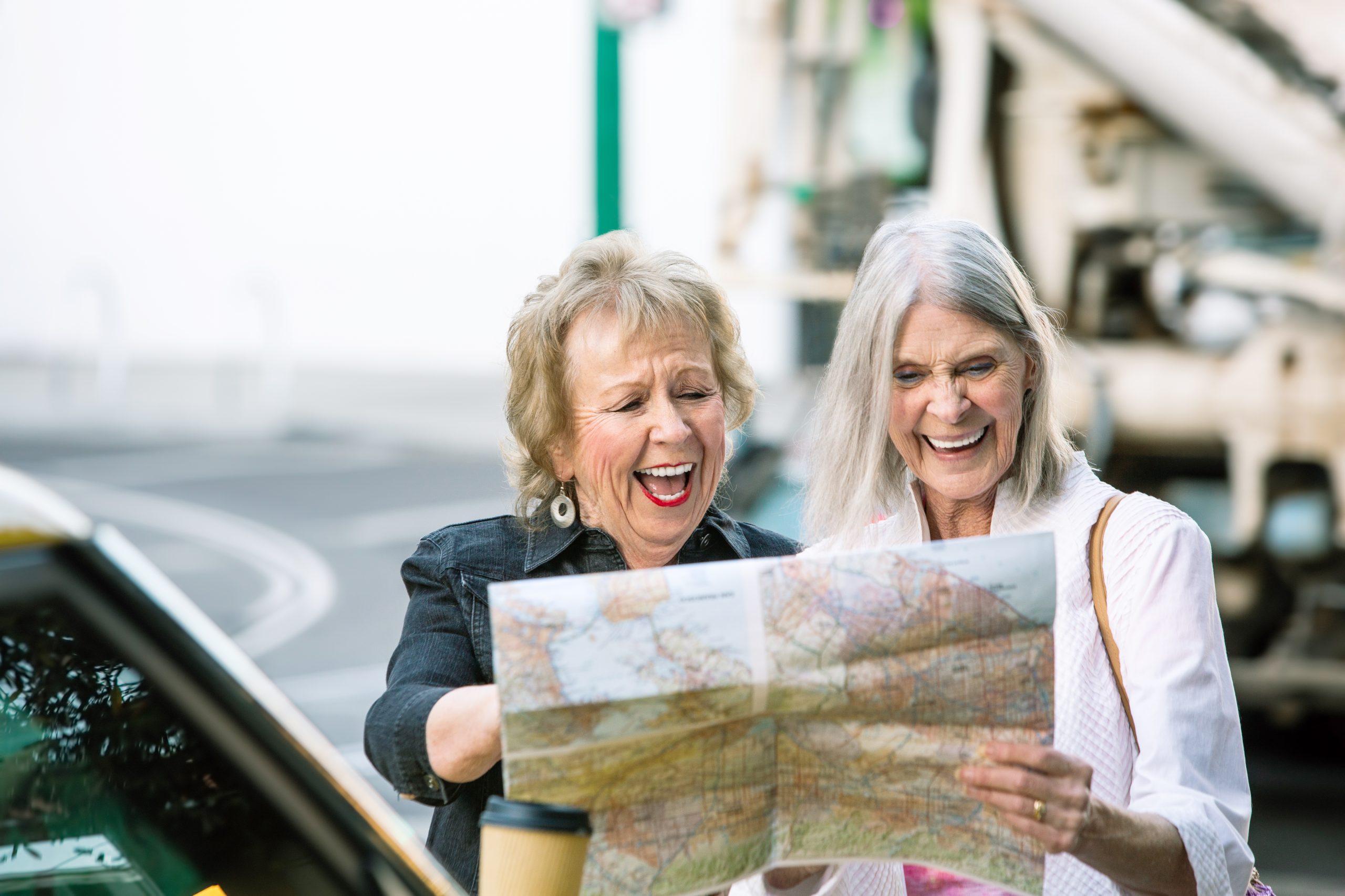 Two Women Checking a Map and Laughing