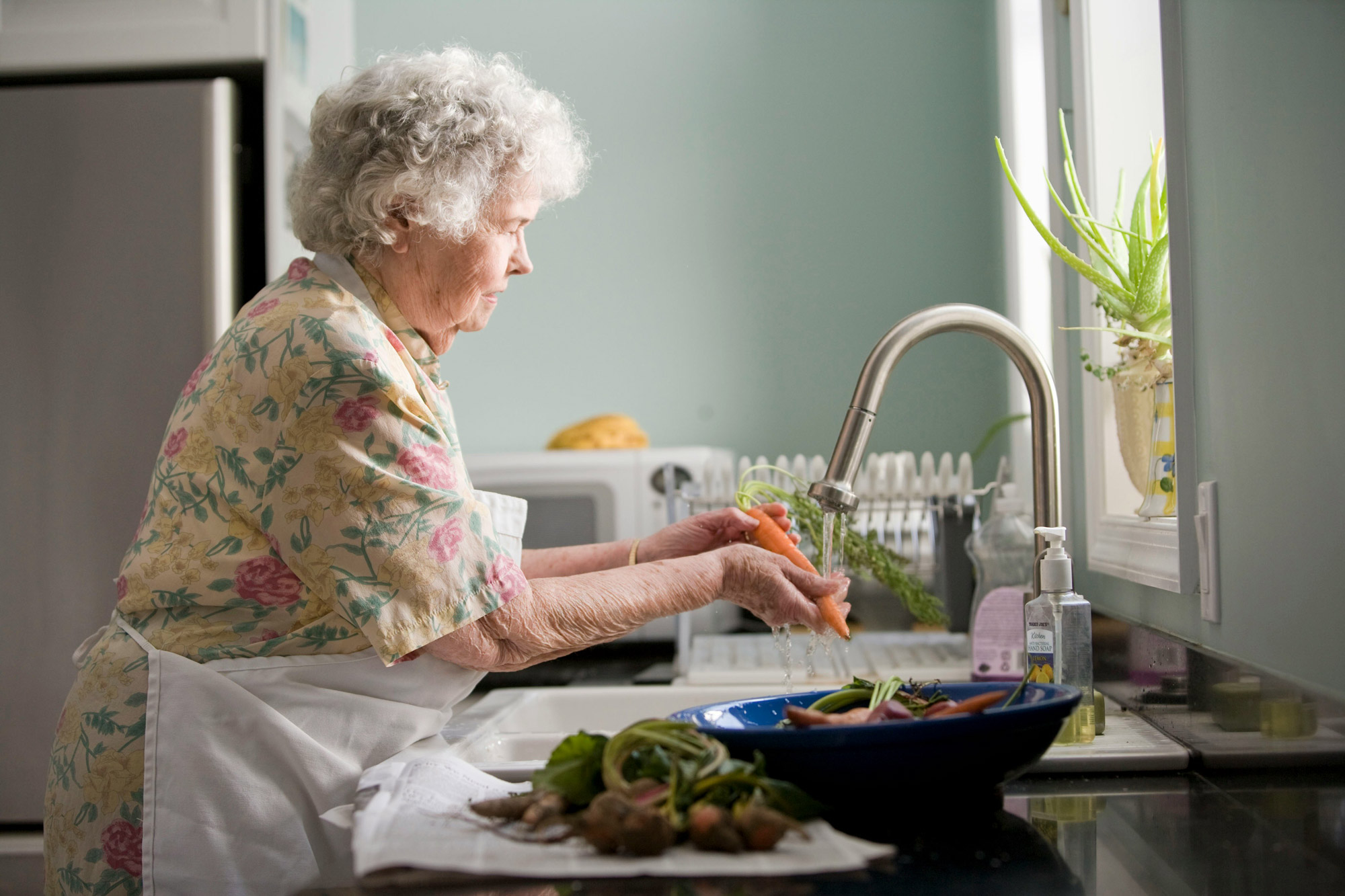 senior washing veggies